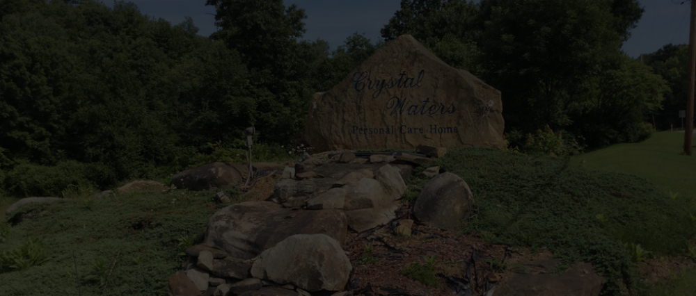 The Crystal Waters stone entrance sign set among the landscaped grounds